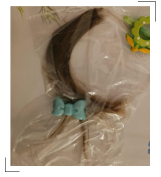 Foto von Kasias erster abgeschnittener Haarlocke und Haarspangen